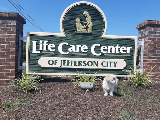 A welcoming sign for the Life Care Center of Jefferson City, accompanied by a pet in the foreground.