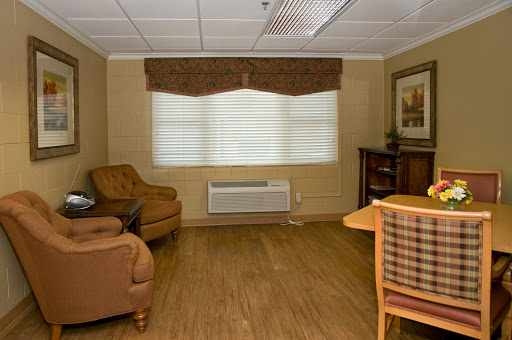 A cozy living room featuring comfortable seating, decorative elements, and a window with blinds.