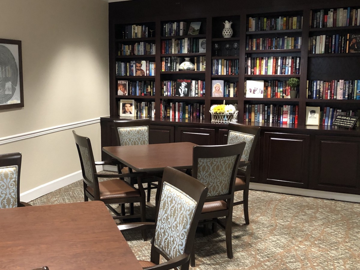 A quiet library space with bookshelves, tables, and chairs for reading and studying.
