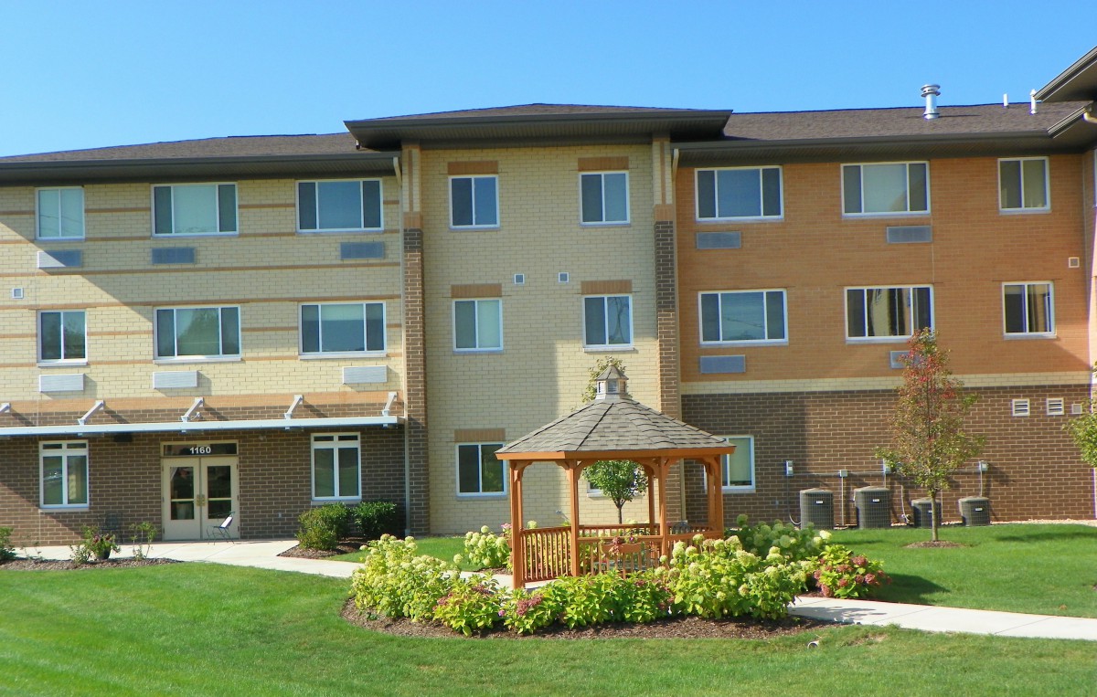 A residential apartment building with a landscaped garden and gazebo.