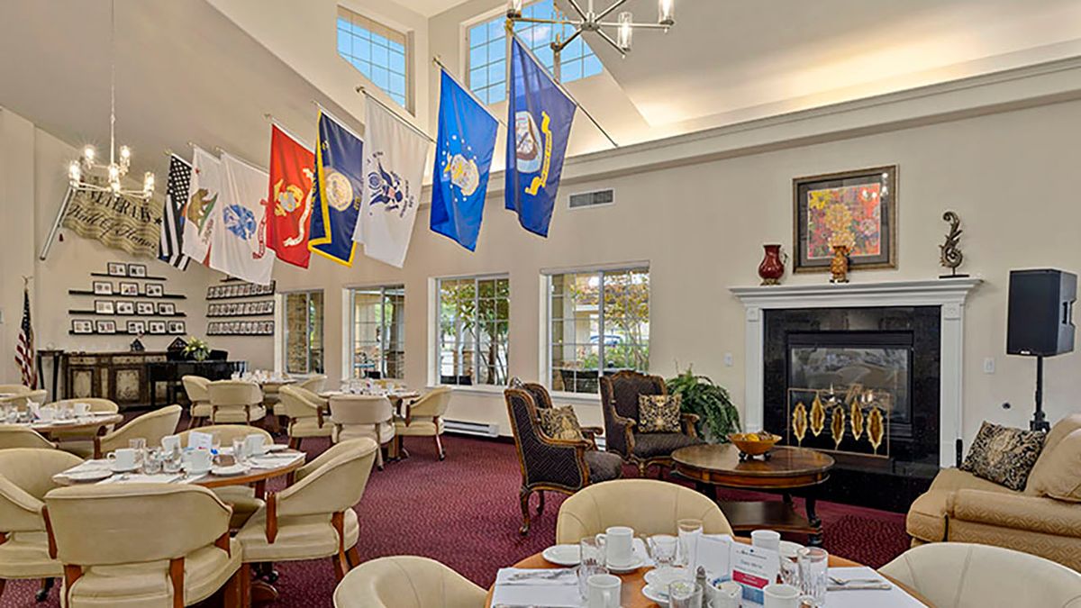 A dining area decorated with military flags and elegant furnishings, featuring a cozy fireplace.