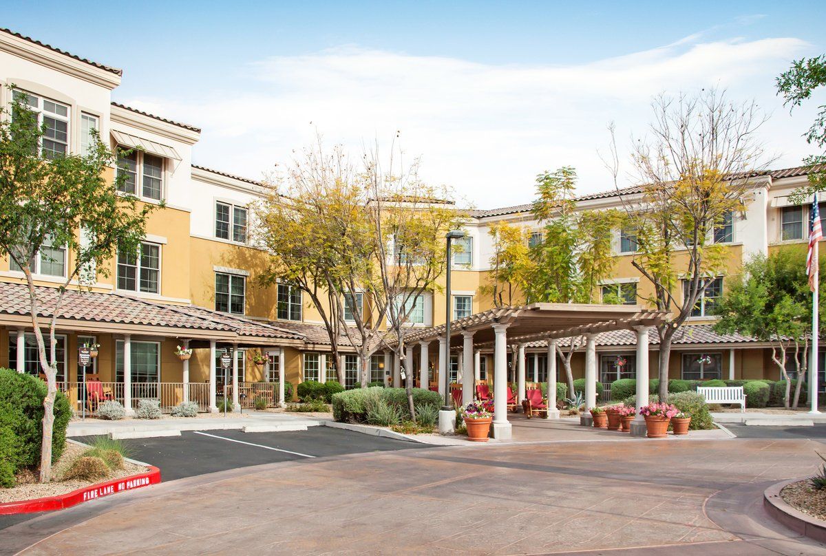 A modern residential building with a well-maintained parking lot and landscaped surroundings.