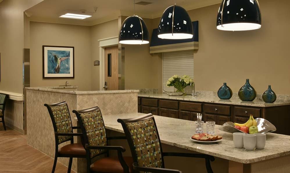 A modern office conference room with a central table, stylish chairs, and overhead lighting.
