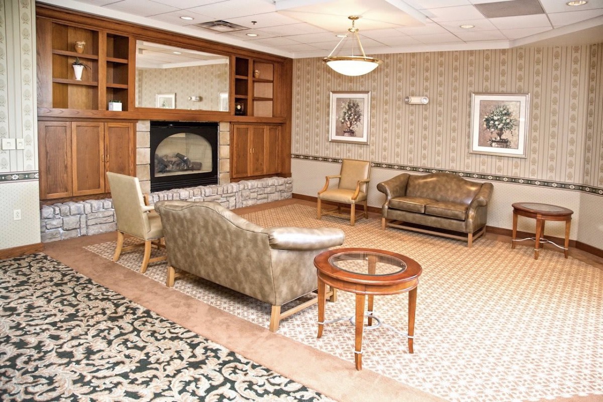 A cozy living room with a fireplace, upholstered seating, and elegant decor.