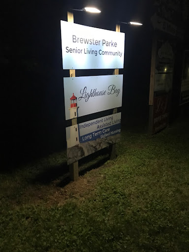 Sign for a senior living community named Lighthouse Bay, illuminated at night.