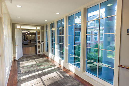 A well-lit hallway with large windows allowing natural light to illuminate the space.