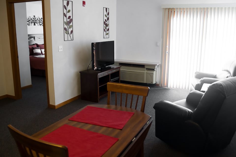 A cozy living room with a dining area, featuring a television and a sofa.