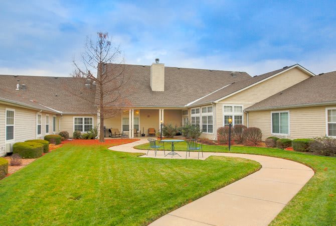 A well-maintained residential building with a green lawn and curved pathway.
