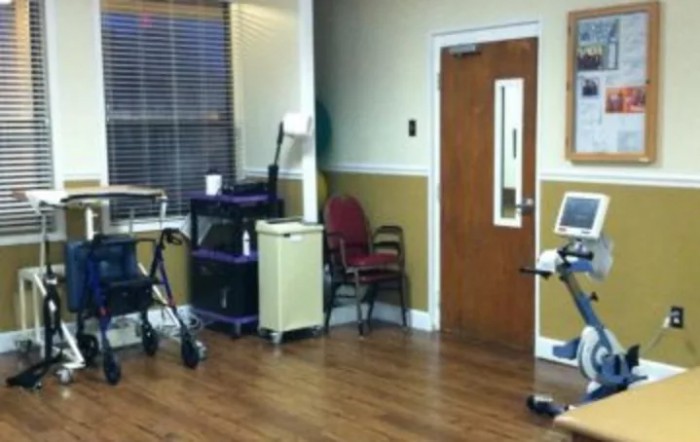 A hospital room with medical equipment and chairs.