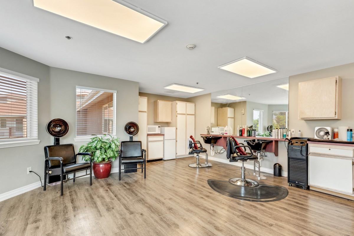 A modern hair salon interior with styling stations and a waiting area.