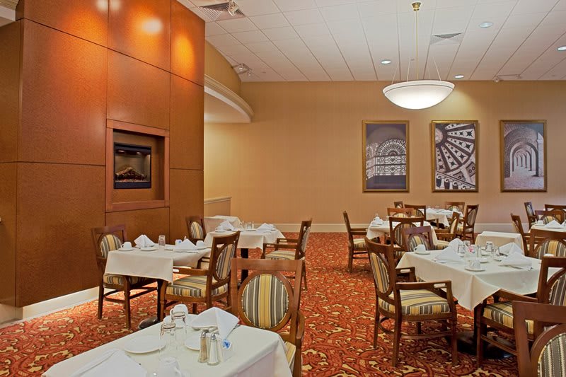 An elegantly decorated restaurant dining area with neatly arranged tables and upholstered chairs.
