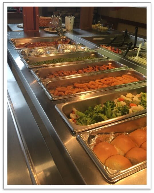 A buffet setup with various food items in trays, ready for self-service at a restaurant.