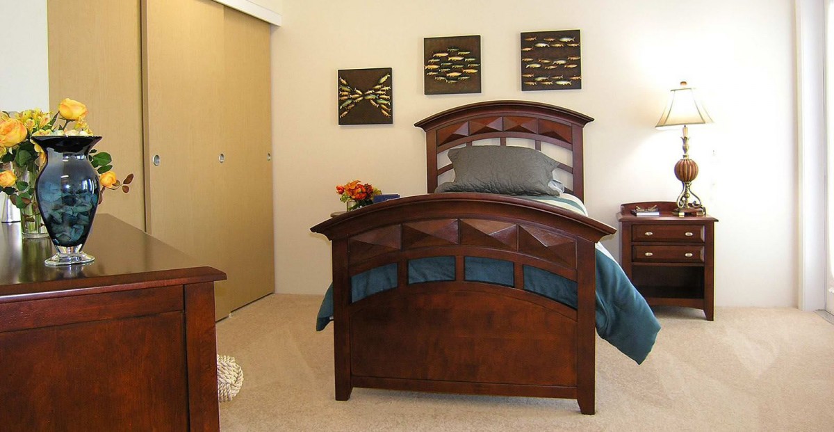 A neatly arranged bedroom featuring a wooden bed and modern decor.