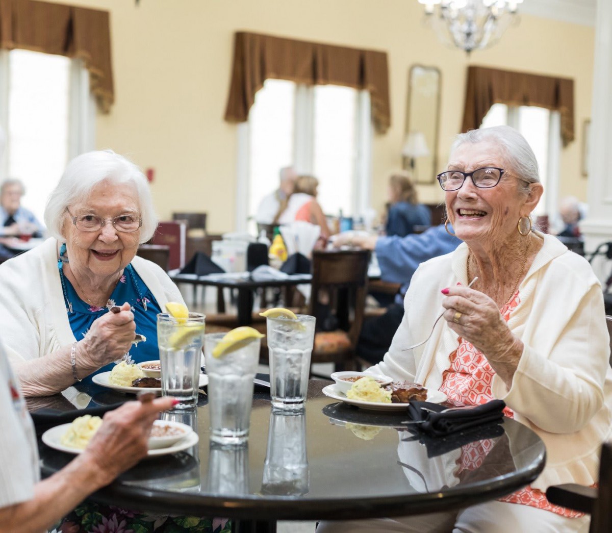 A group of elderly women enjoying a meal together in a dining setting.