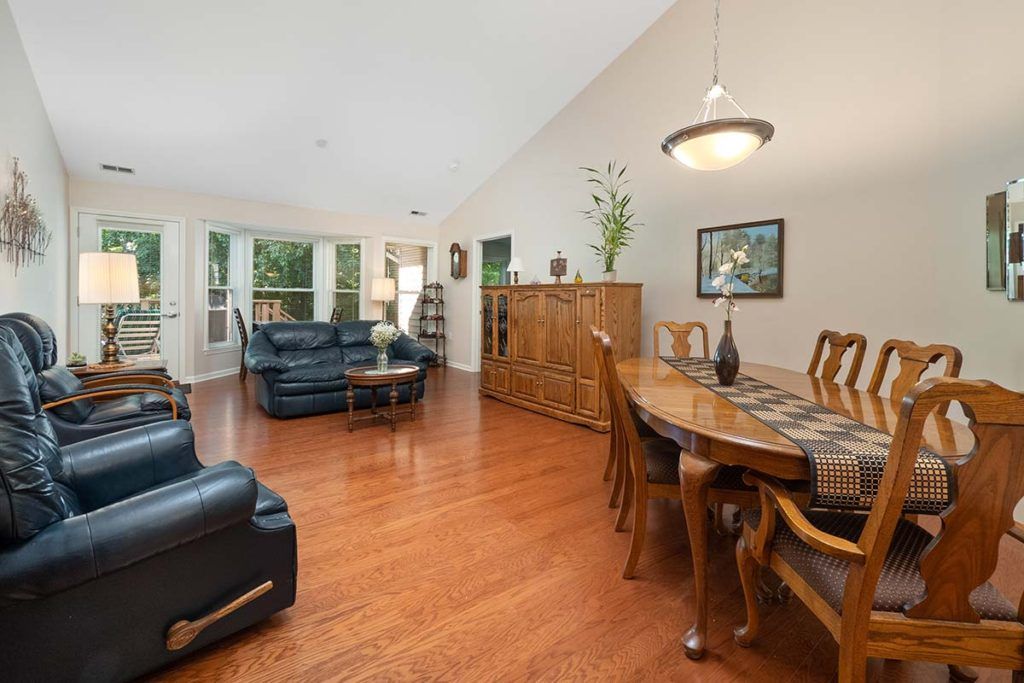 Spacious living and dining area with hardwood flooring and elegant furniture.