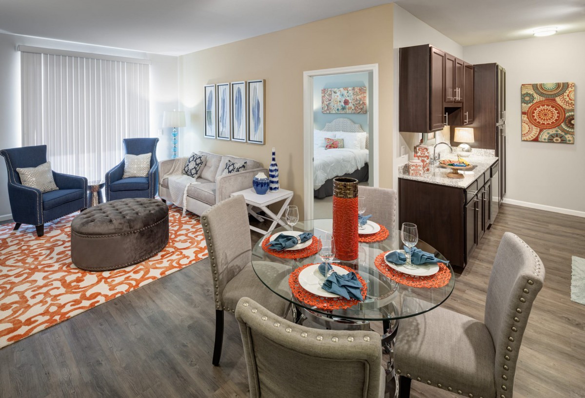 A modern apartment interior with a cozy living room, dining area, and kitchen.