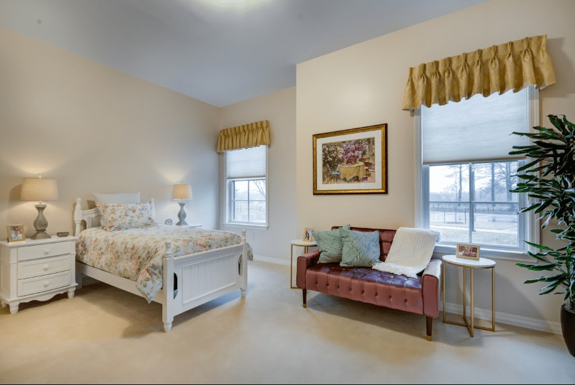 A cozy bedroom with a bed, sofa, and elegant decor.