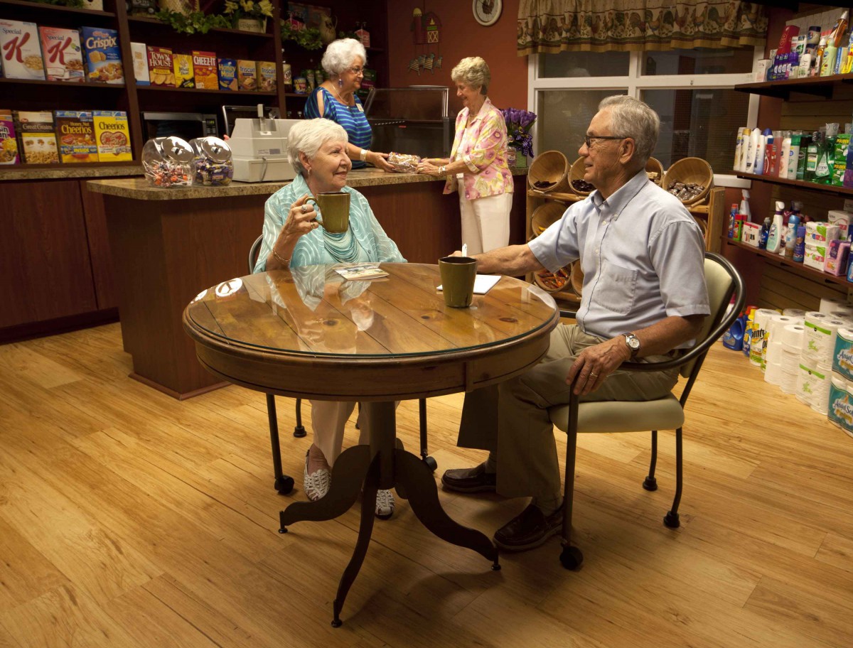 Elderly individuals enjoying a conversation over coffee in a cozy setting.