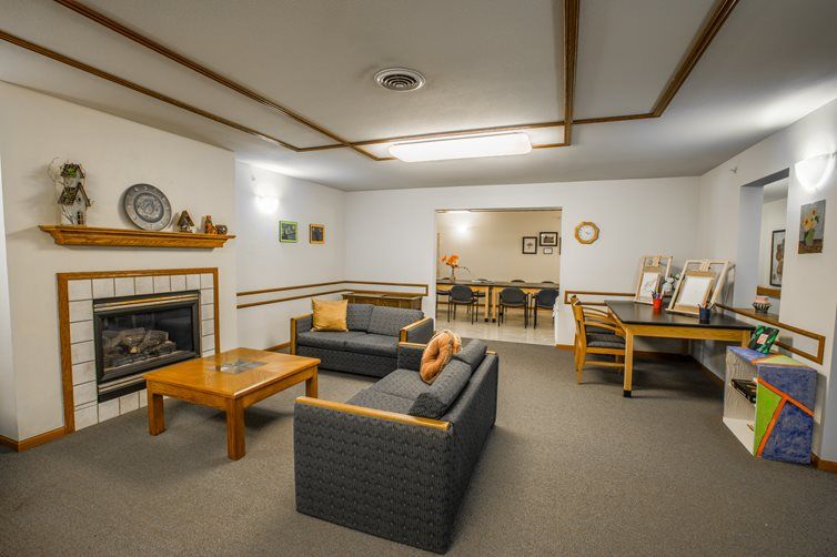A cozy living room with sofas, a fireplace, and a coffee table arranged for comfortable seating.