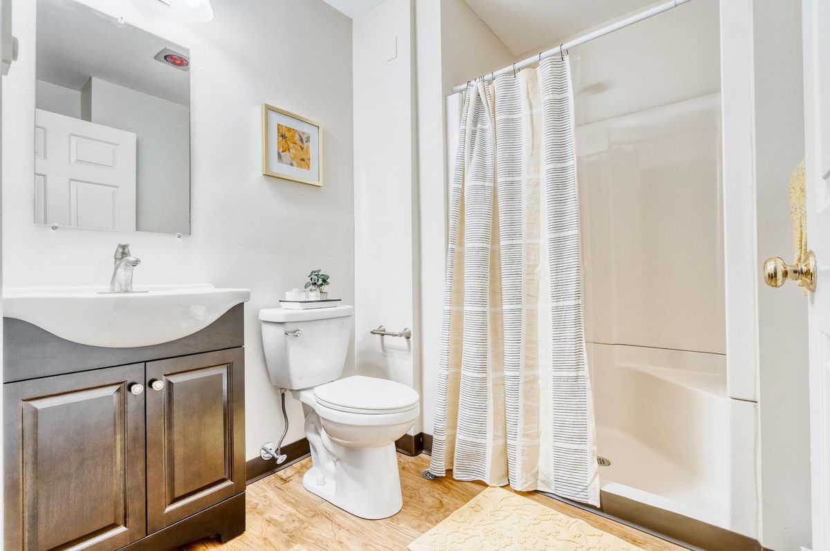 A clean and modern bathroom with a shower, sink, and toilet.