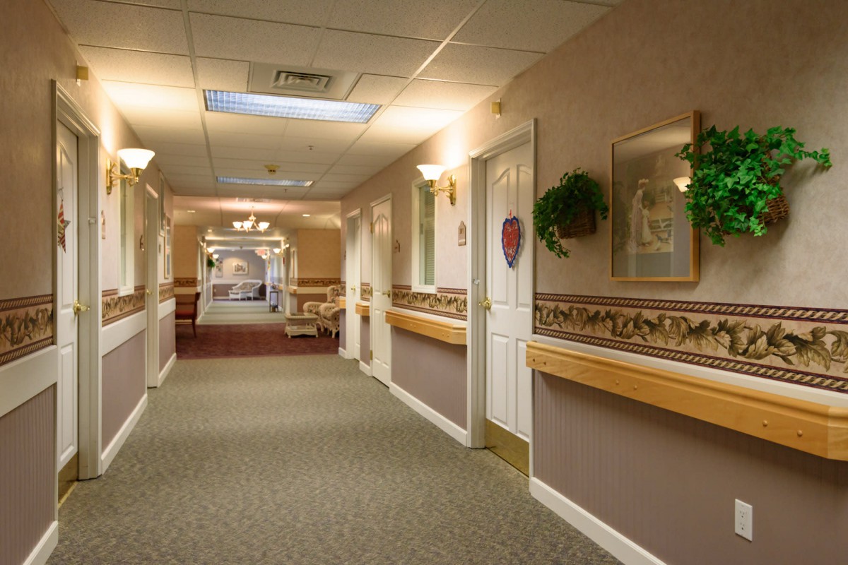 A warmly lit hallway with decorated walls and multiple doors.