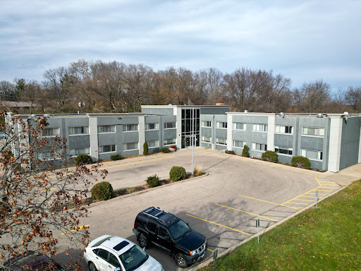 Aerial view of a modern apartment complex with an adjacent parking lot.