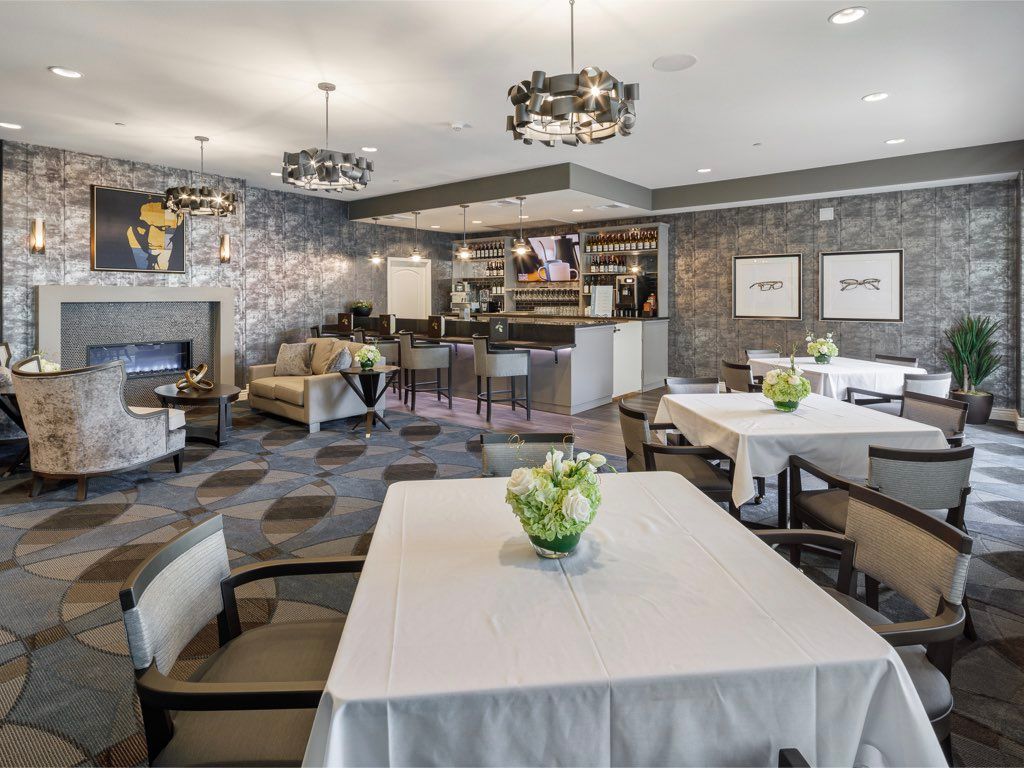 A modern restaurant interior with dining tables and elegant chandeliers.