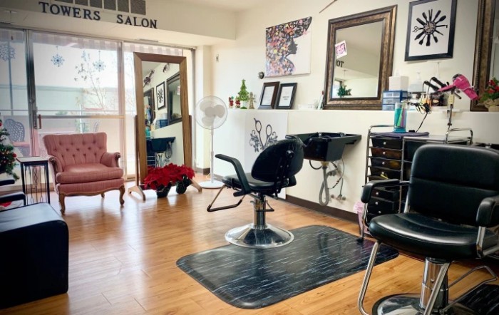 A cozy salon interior with a styling chair, mirror, and elegant decor.