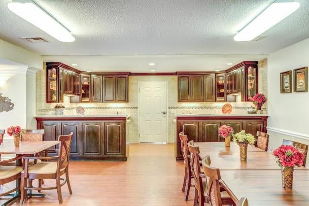 Spacious kitchen with wooden cabinets and a large dining table.
