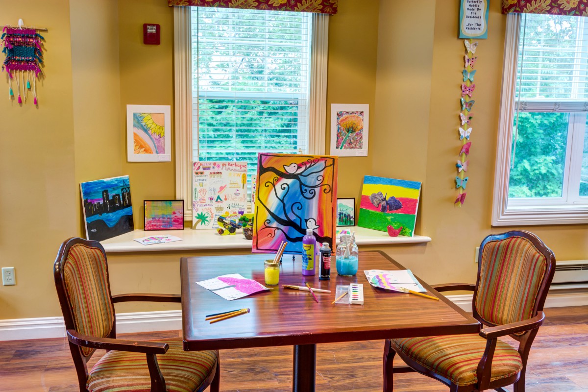 A cozy room with a table showcasing colorful artworks and crafts.