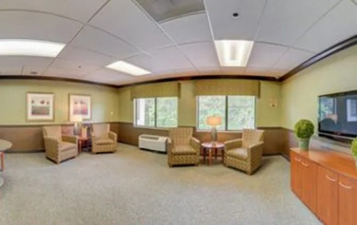 A well-lit waiting room with comfortable chairs and large windows.