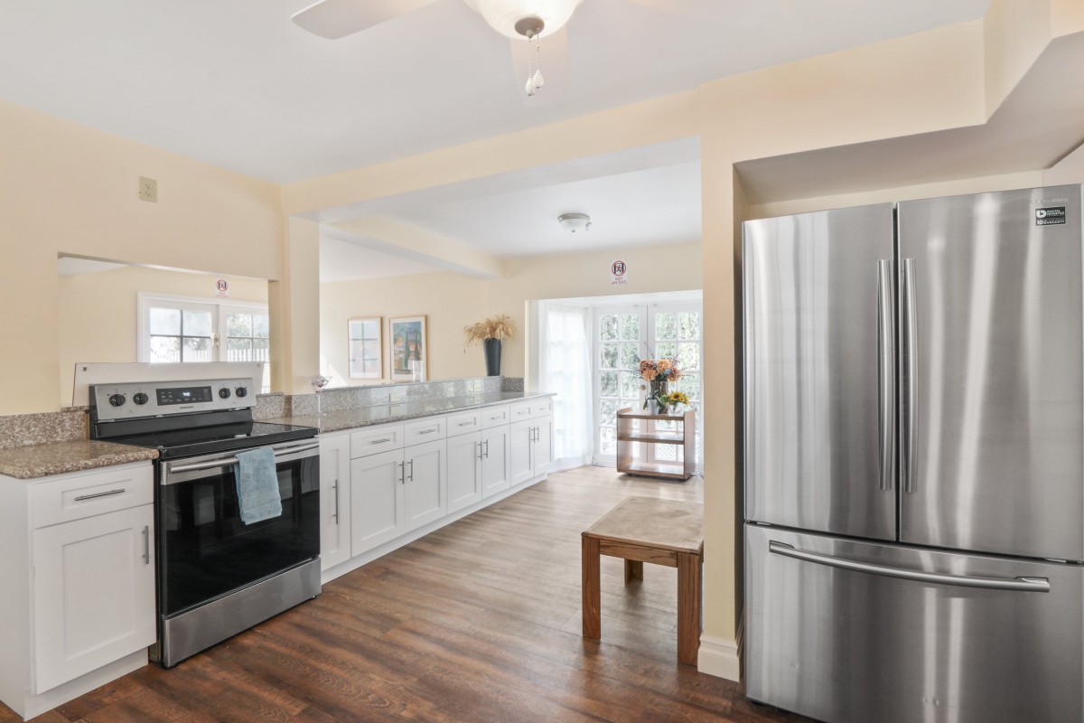 A modern kitchen with stainless steel appliances and hardwood flooring.