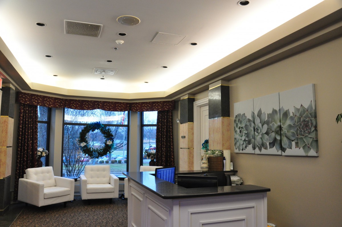 A modern reception area with comfortable seating and a decorative wreath on the window.