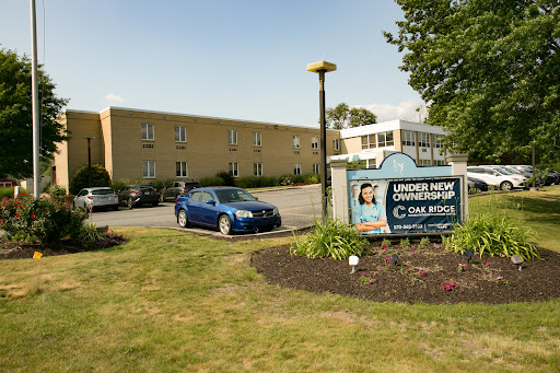 Exterior view of a commercial building with signage and vehicles in the parking area.
