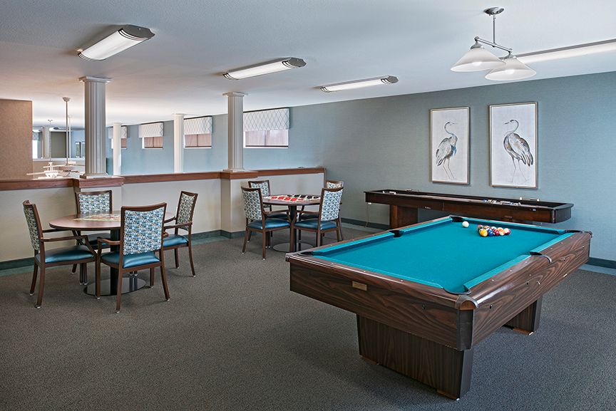 A modern game room featuring a pool table and seating area.