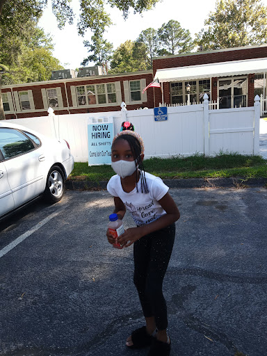 A child joyfully playing outside while wearing a mask.