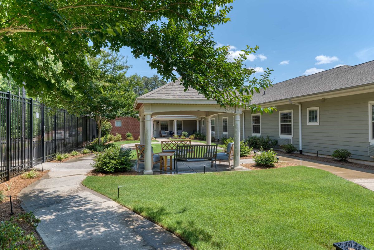 A beautifully landscaped garden featuring a gazebo and pathway leading through lush greenery.