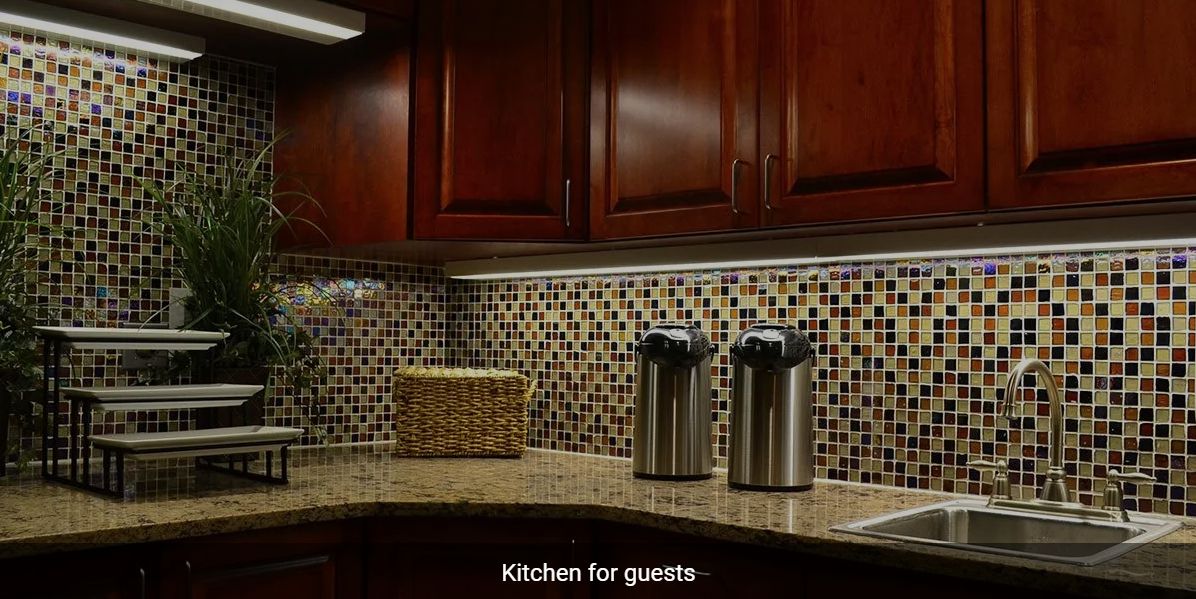 A cozy kitchen setup with mosaic backsplash and coffee dispensers.