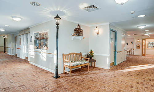 A cozy hallway with a wooden bench, decorative artwork, and a unique indoor lamp post.