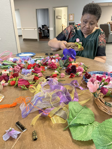 A creative workspace filled with colorful artificial flowers and ribbons, showcasing a crafting activity.