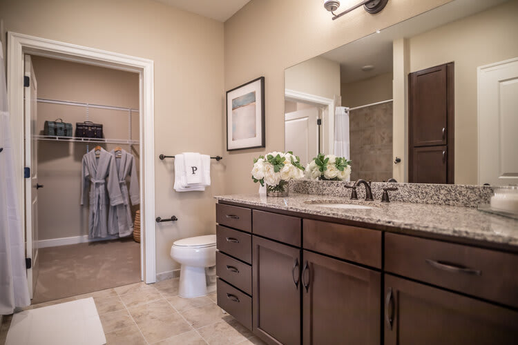 A modern bathroom with a double sink vanity, large mirror, and elegant cabinetry.