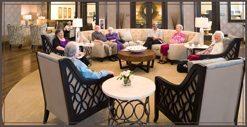 A group of seniors gather in a cozy living room for a conversation.