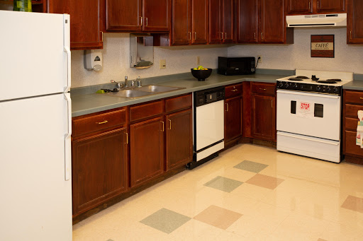 A modern kitchen featuring wooden cabinets, a countertop, and essential appliances.