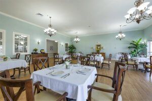 An elegant dining room with neatly arranged tables and chandeliers.