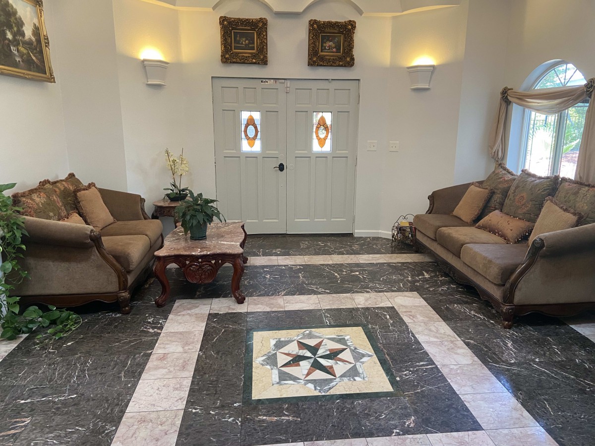 A classic living room with twin sofas facing each other, a central coffee table, and intricate tiled flooring.