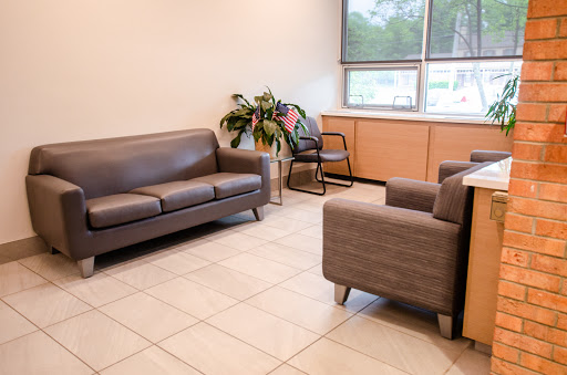 A cozy waiting area featuring a sofa, armchairs, and a touch of greenery.