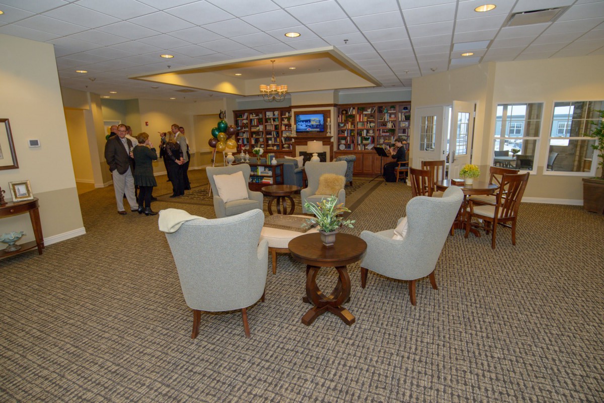 A comfortable lounge area with chairs and tables, where people are gathered.