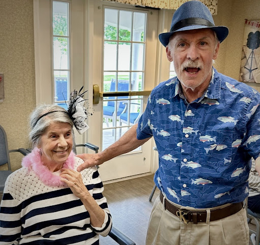 A cheerful moment shared between a stylish elderly couple, celebrating life indoors.
