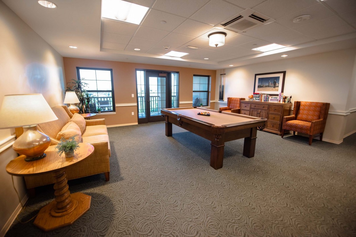 A cozy recreation room featuring a pool table and comfortable seating.