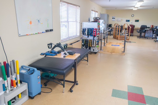 A view of a physical therapy room equipped with various rehabilitation tools and exercise equipment.